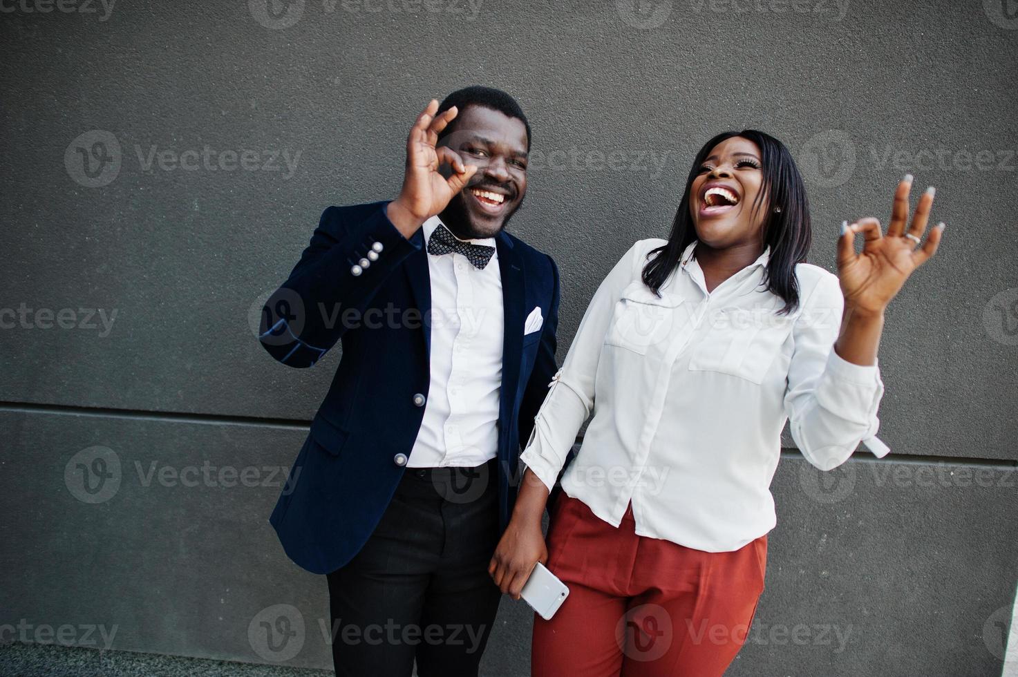 Stylish african american couple in formal wear. Romantic couple in love dating. They show ok fingers. photo