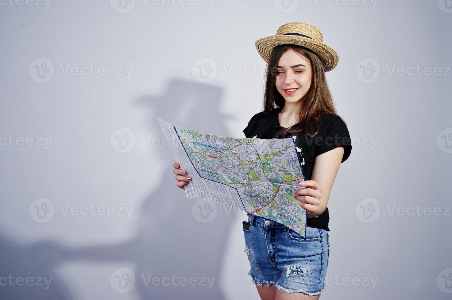 Girl tourist with map, wear in lol shirt, shorts and hat isolated on white. photo