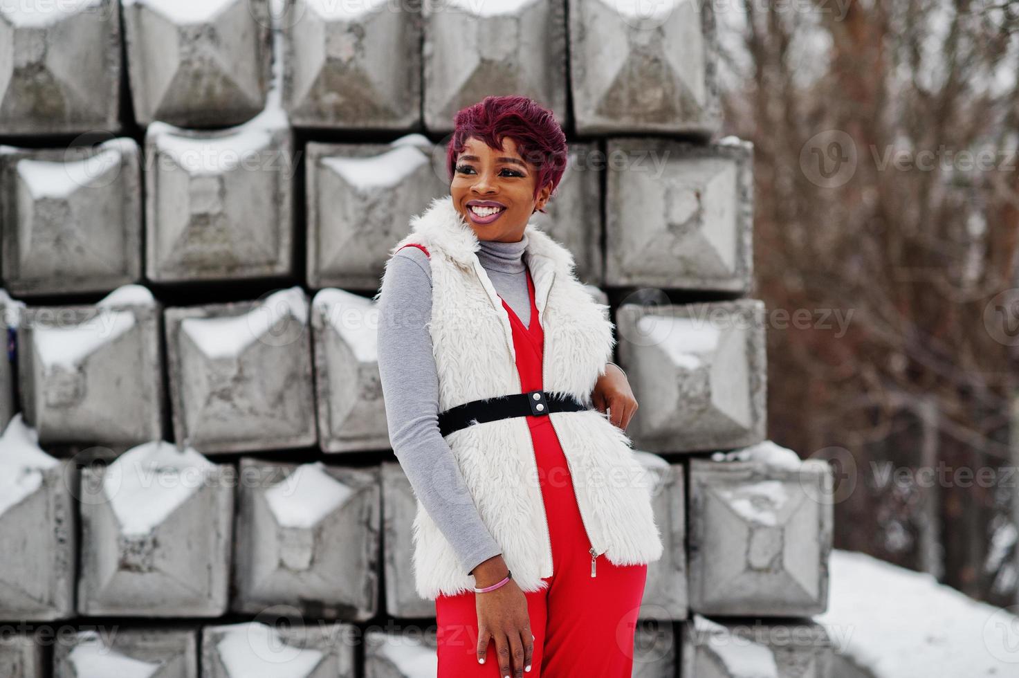 African american woman in red pants and white fur coat jacket