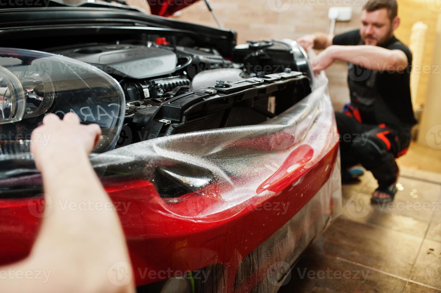 El trabajador del servicio de automóviles puso una película antigravilla en  una carrocería de automóvil roja en el taller de detalles de vehículos  protección de automóviles con películas especiales