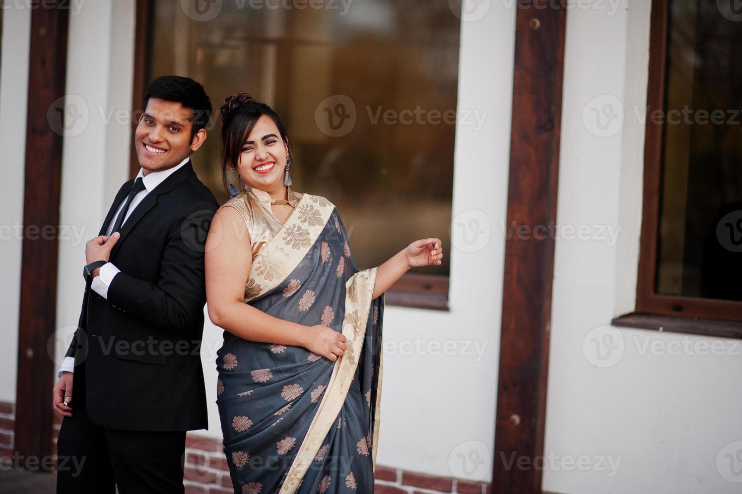 Elegant and fashionable indian friends couple of woman in saree and man in suit. photo