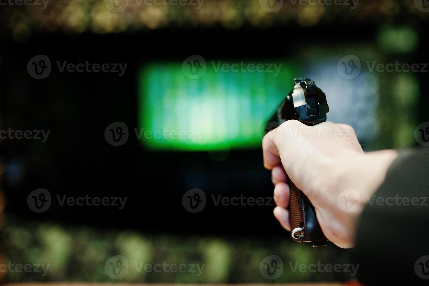 Hand of man with gun aim at shooting range. photo