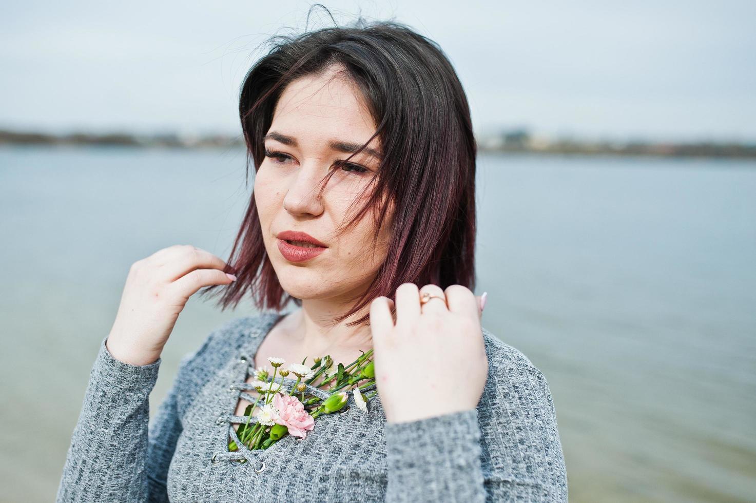 Portrait of brunette girl in gray dress background the lake. photo