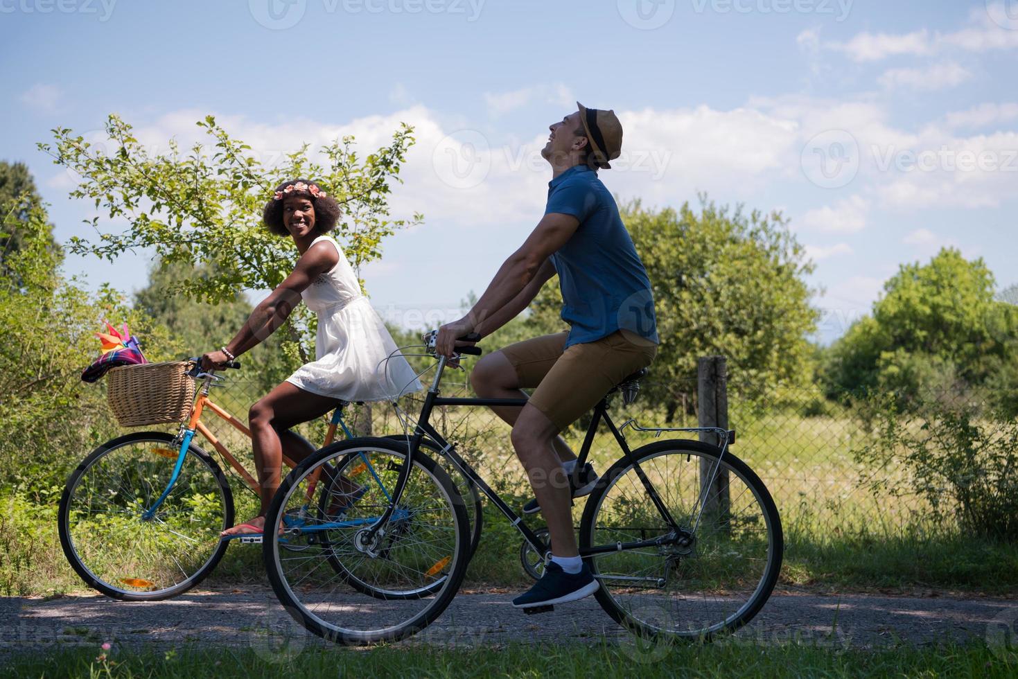 Young multiethnic couple having a bike ride in nature photo