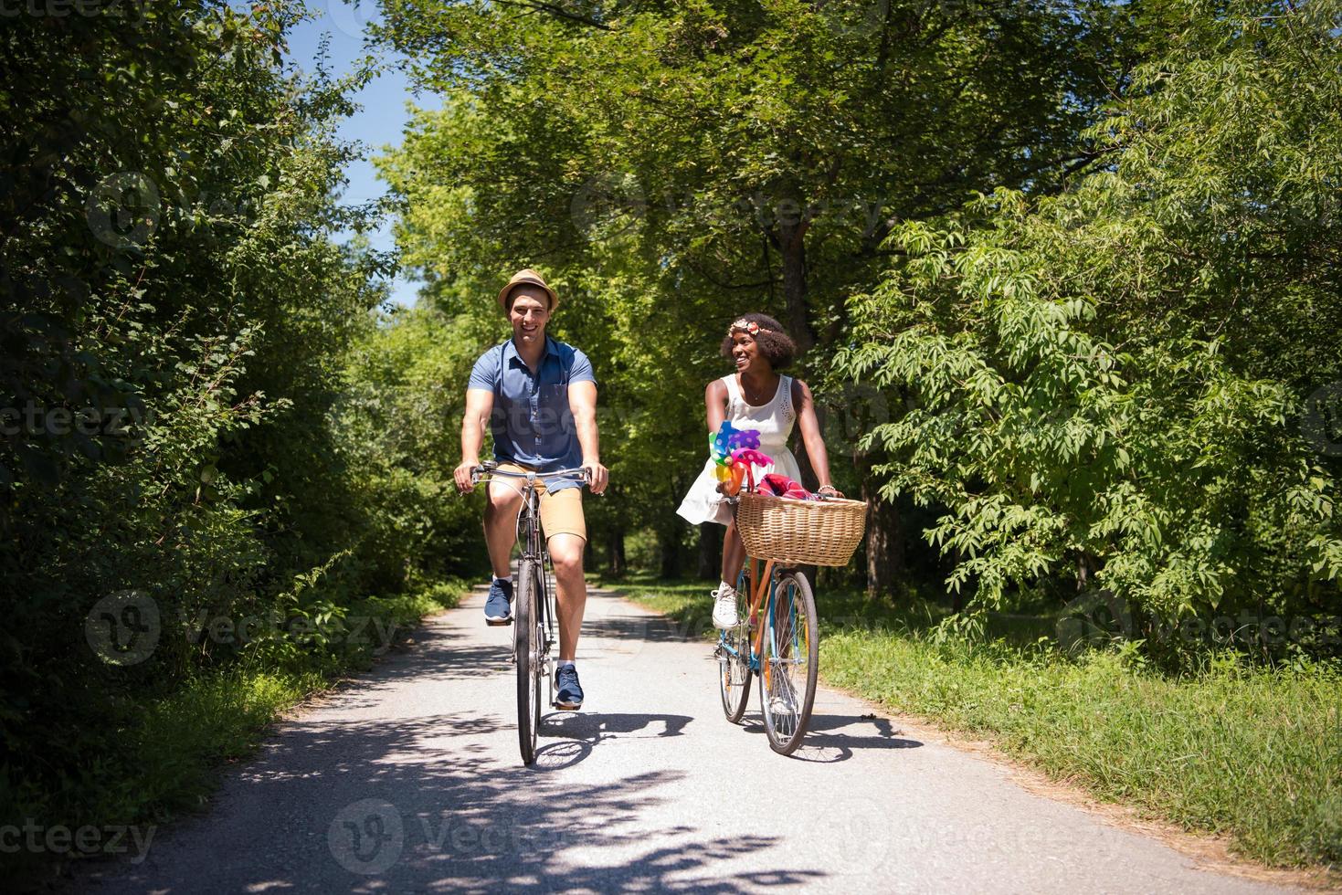 Young multiethnic couple having a bike ride in nature photo