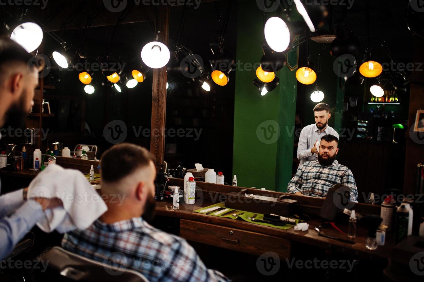 Handsome bearded man at the barbershop, barber at work. photo