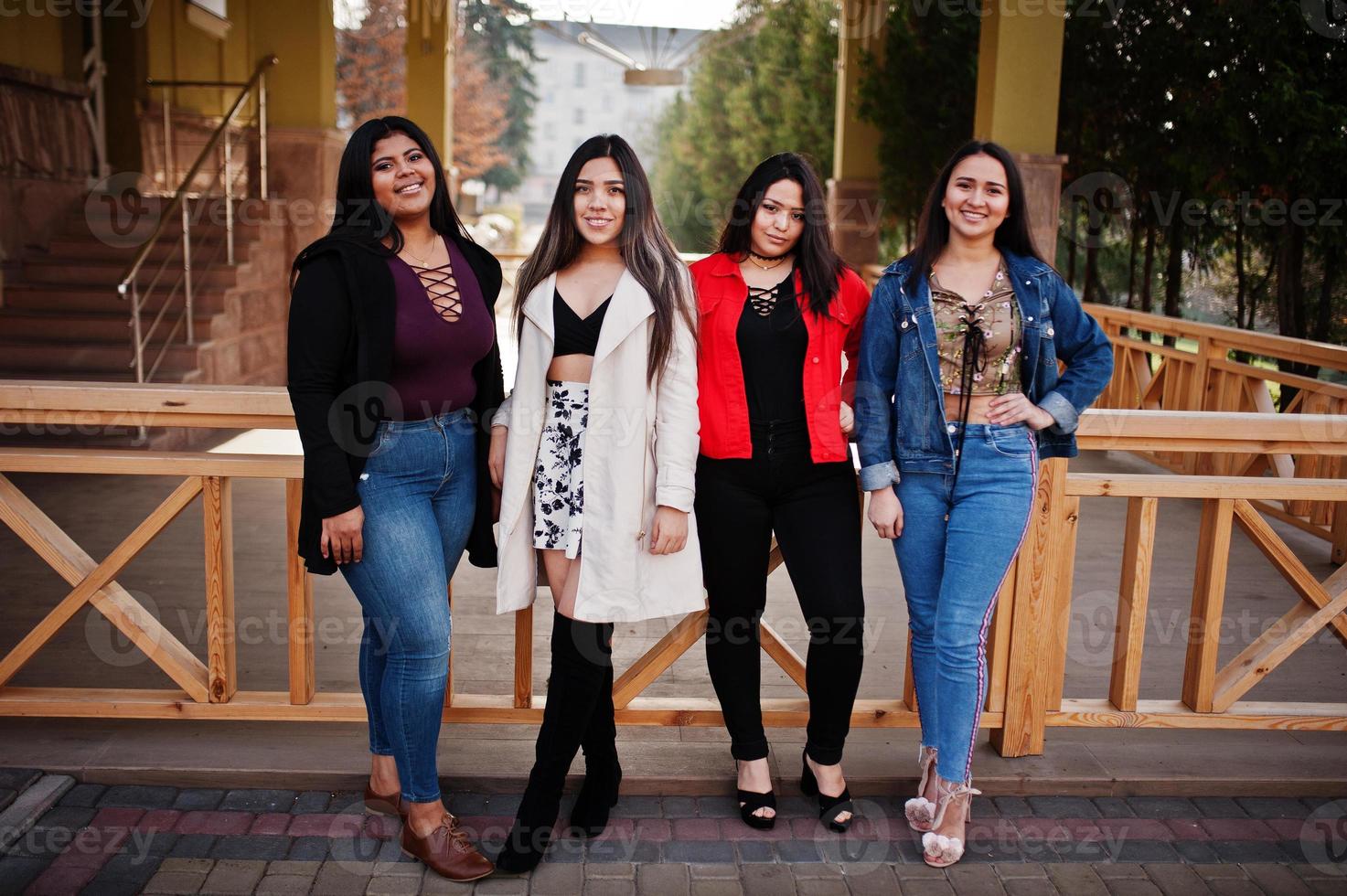 Group of four happy and pretty latino girls from Ecuador posed at street. photo