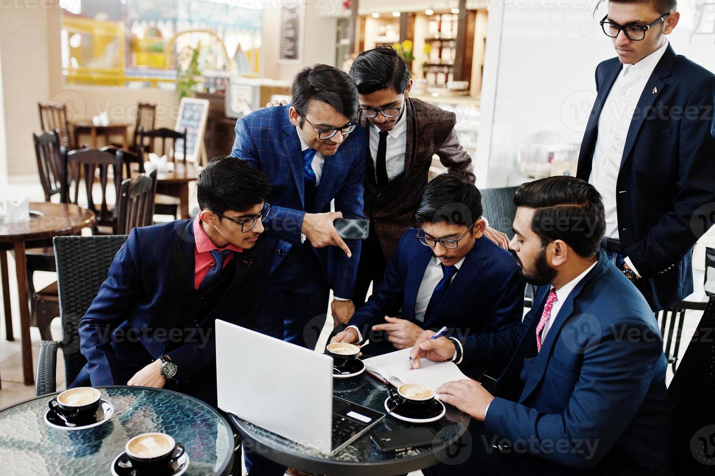 proceso colaborativo de hombres de negocios indios durante una reunión de lluvia de ideas en la oficina. equipo diverso de jóvenes vestidos con trajes que cooperan en el desarrollo de un proyecto común. foto