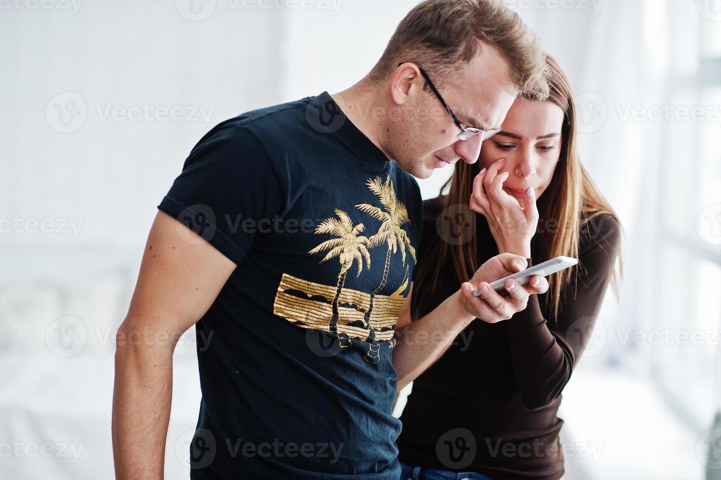 Man with girl looking at mobile phone. Work team discuss something. photo