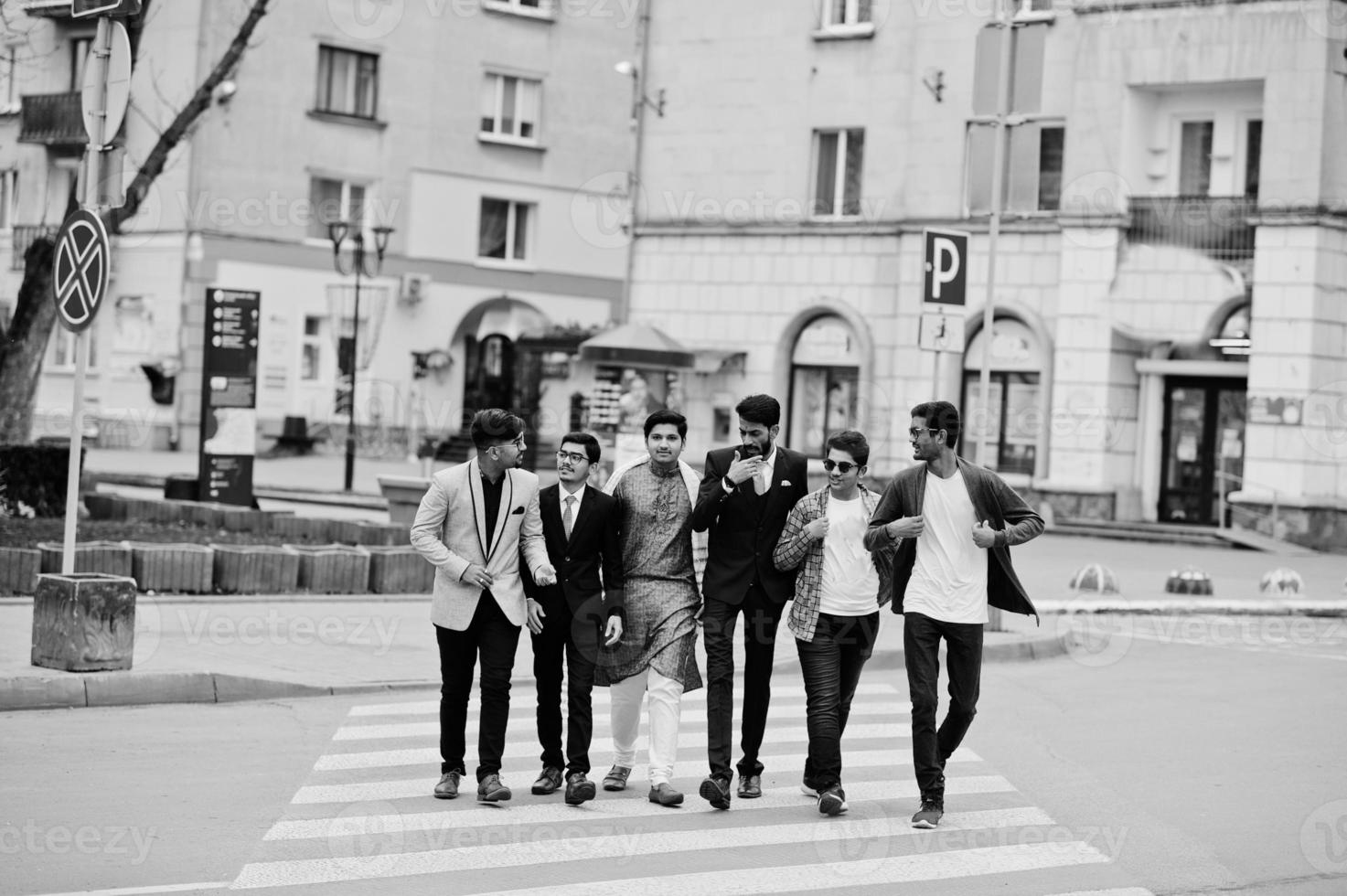 Group of six south asian indian mans in traditional, casual and business wear walking at crosswalk together. photo