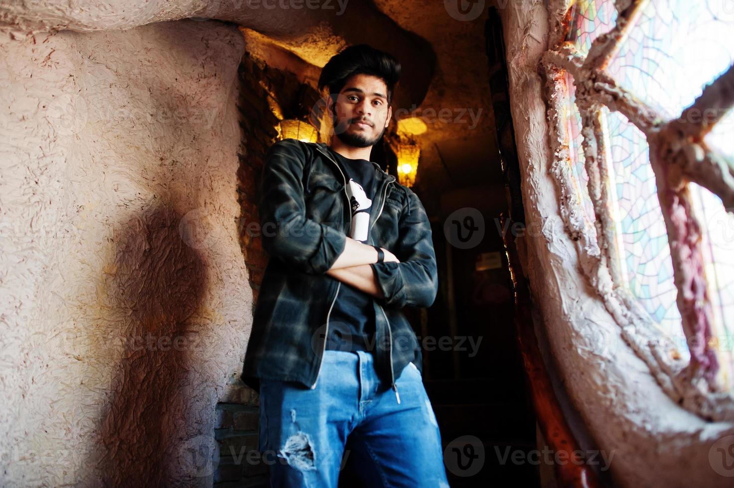 Beard asian man in casual wear stand inside house on stairs against window. photo