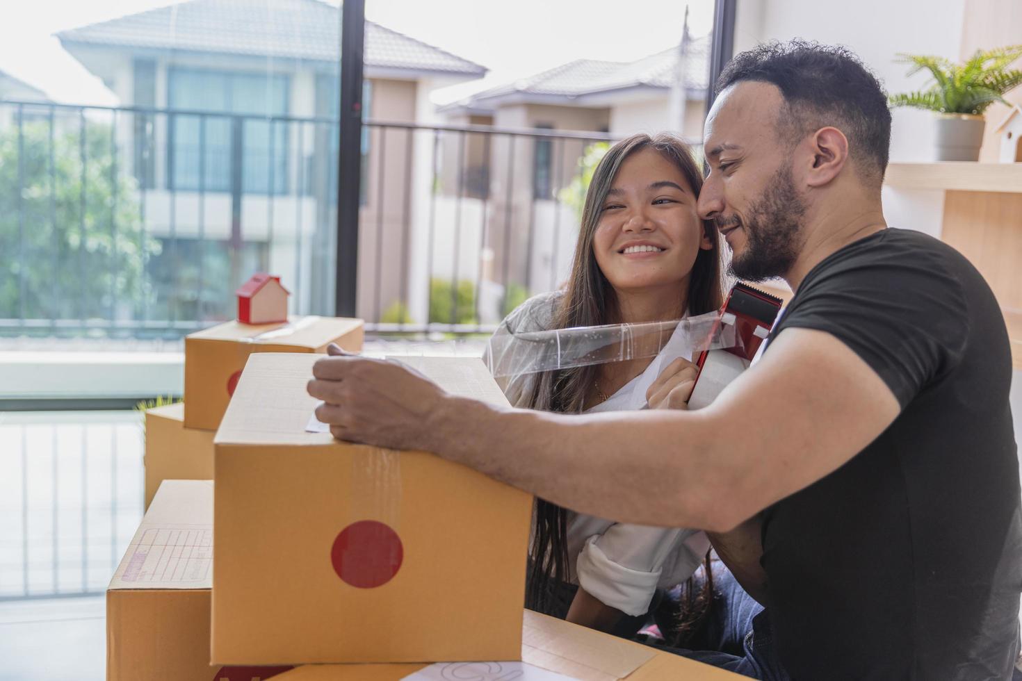 el concepto de mudanza. primer plano de una pareja empacando cajas de cartón para mudarse a un nuevo hogar. foto