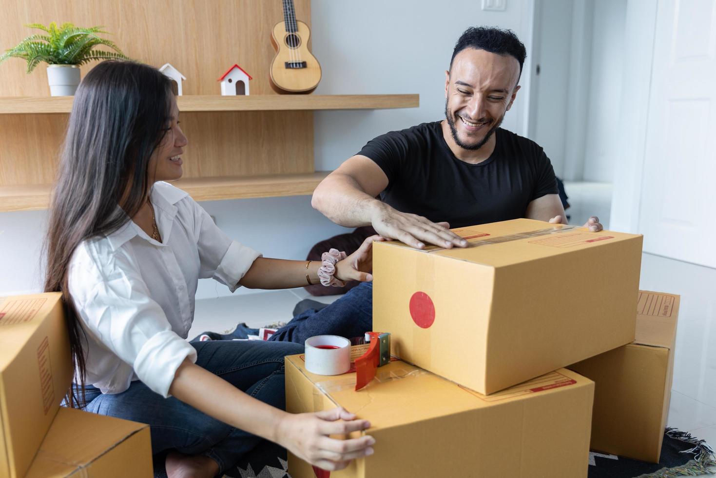 A couple with a big box in their new home. Carrying things into a new home photo