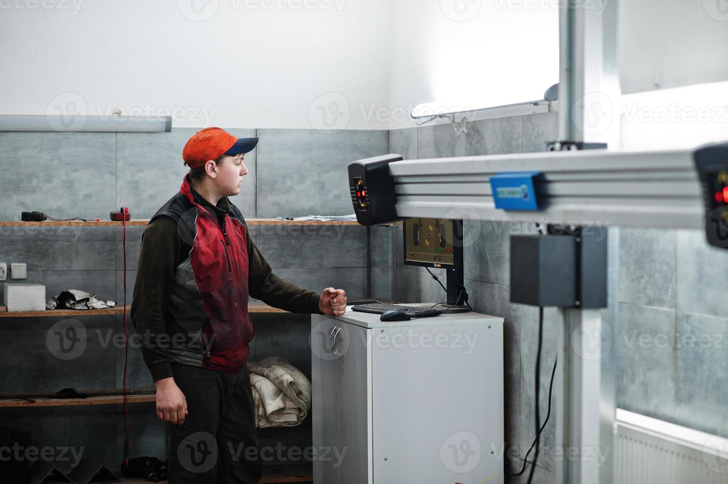 Auto mechanic sets american SUV car for diagnostics and configuration camber check in workshop of service station.. photo