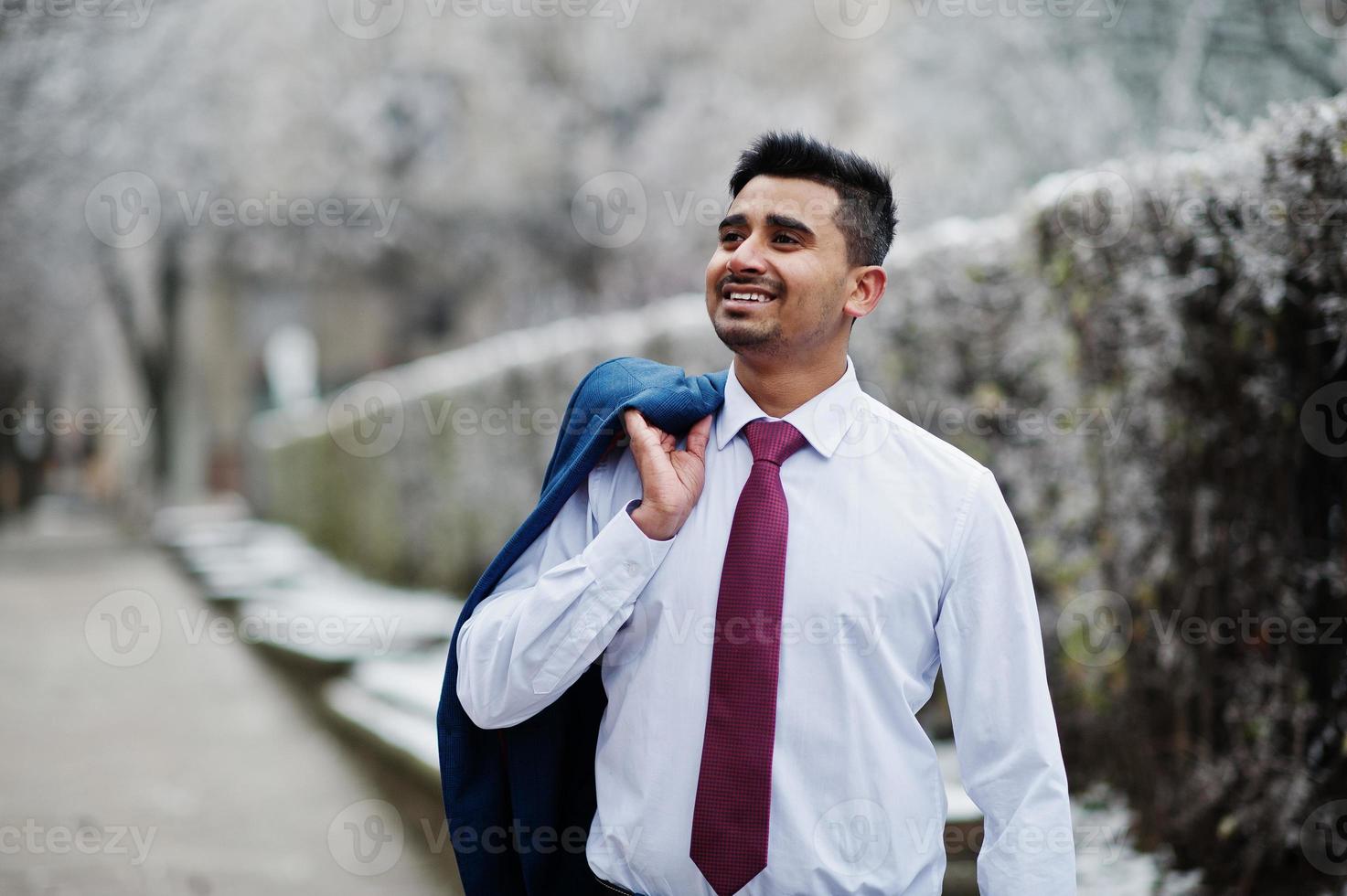 elegante modelo de hombre de moda indio en traje posado en el día de invierno. foto