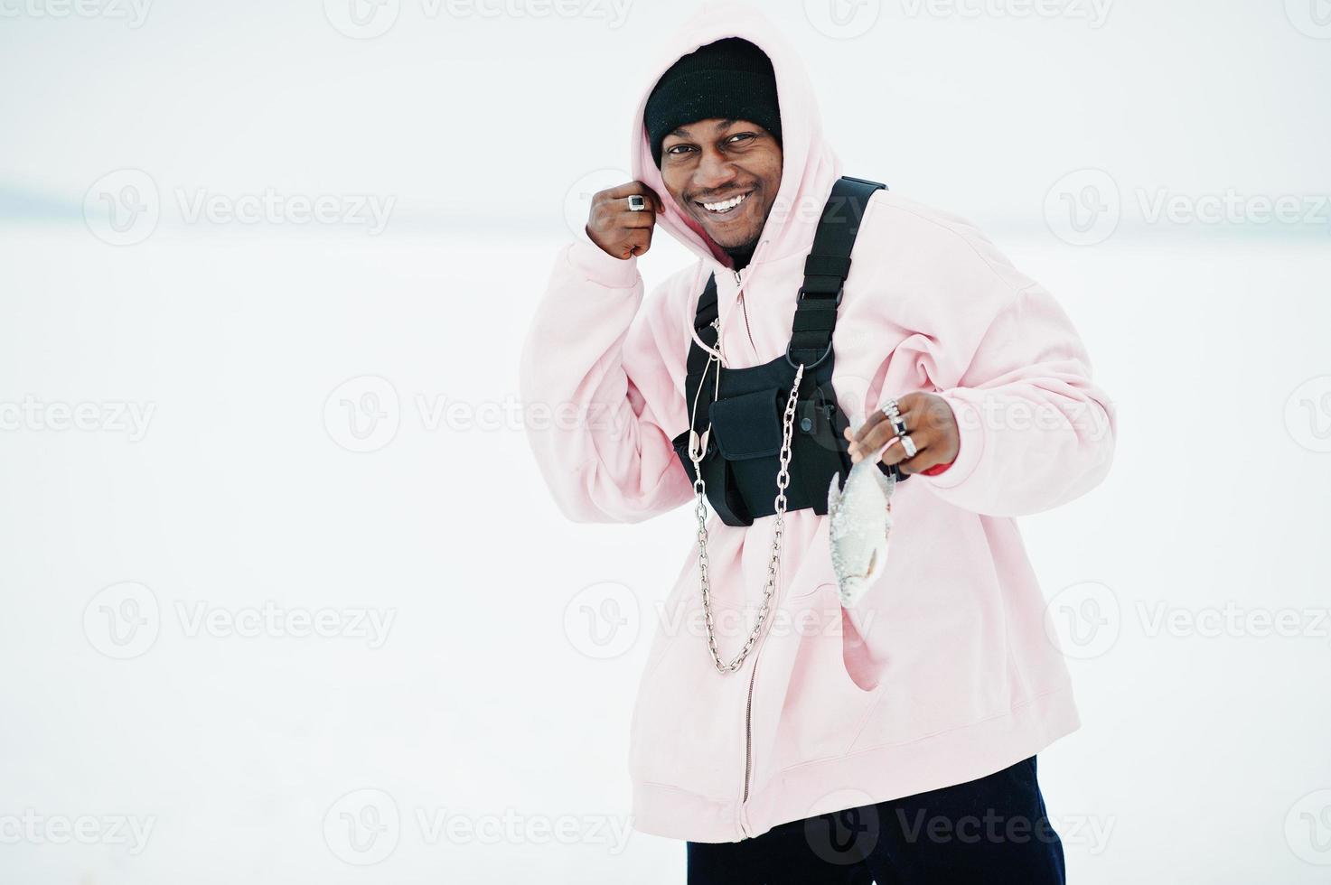 African american fisherman with fresh frozen fish at hand. Winter fishing. photo