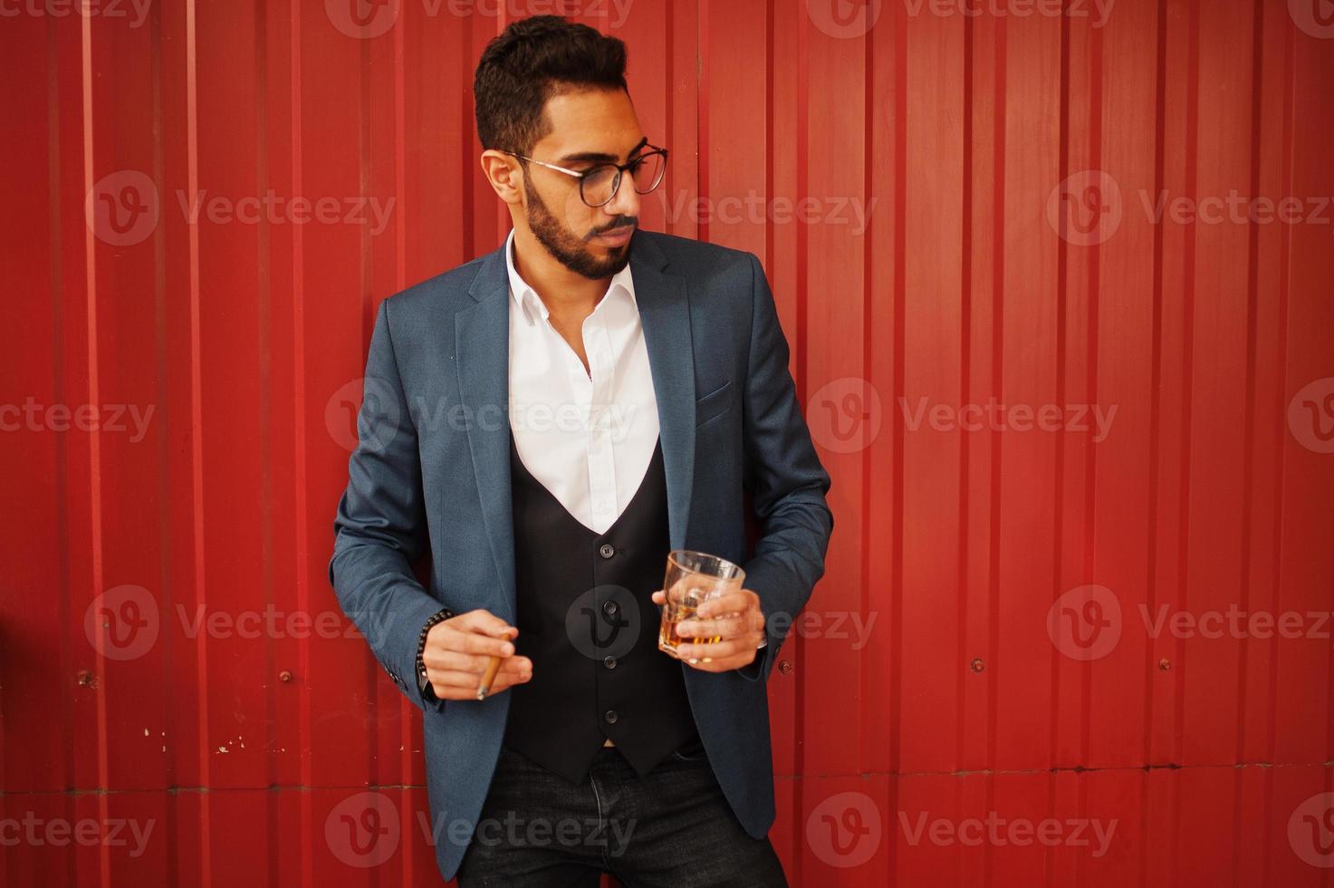 Handsome well-dressed arabian man smoke cigar with glass of whiskey at balcony of pub. photo