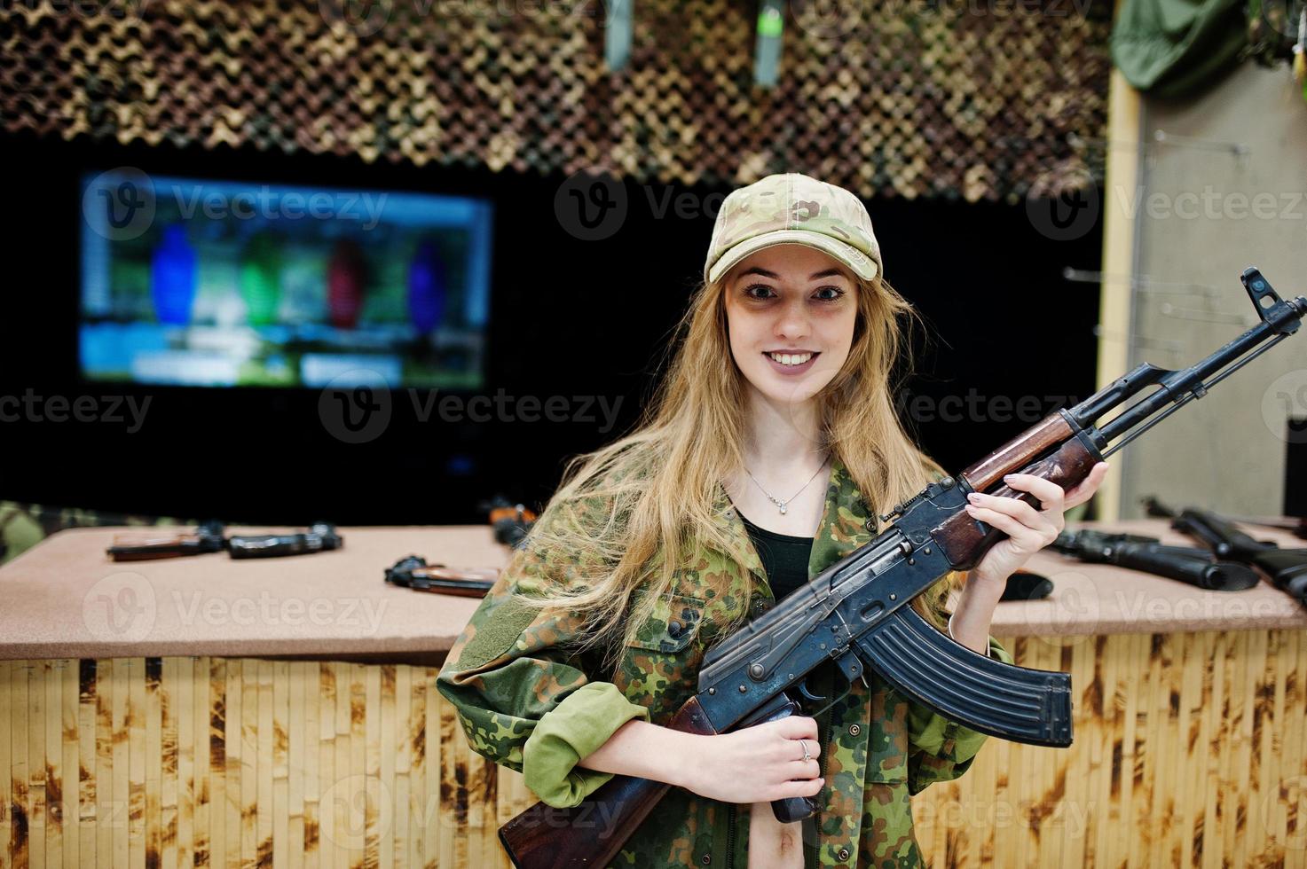Girl with machine gun at hands on shooting range. photo