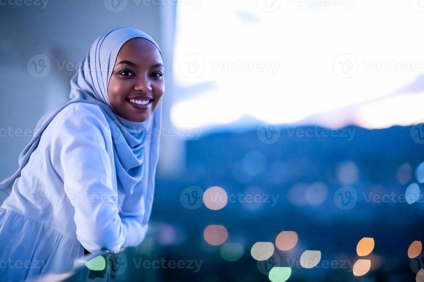 African  modern Muslim woman in night at balcony photo