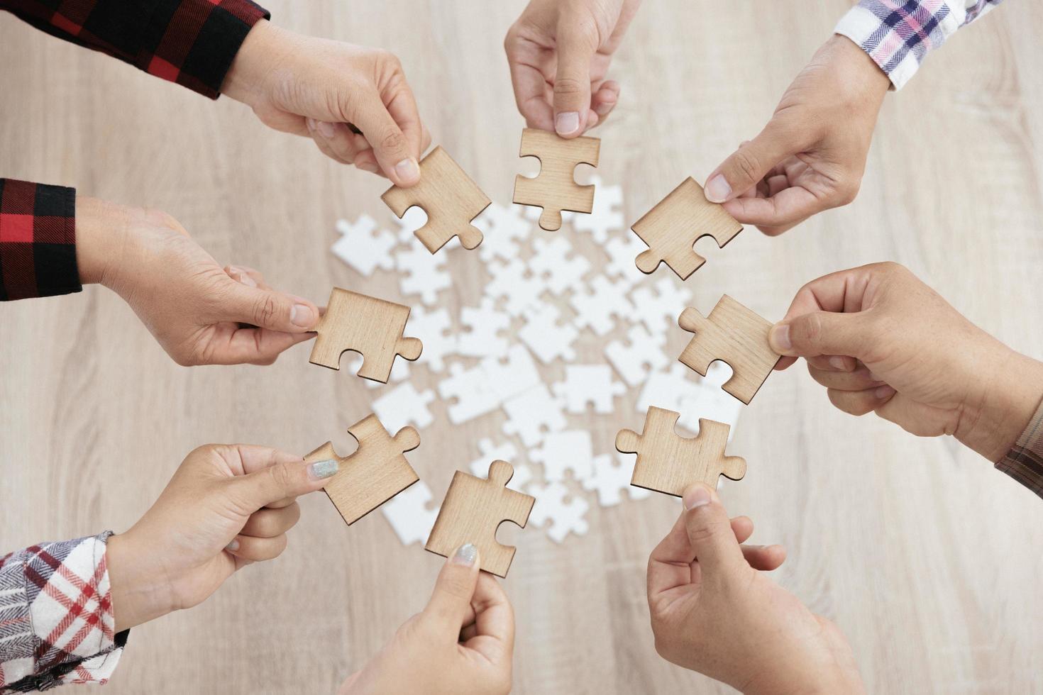 A group of business people assembling jigsaw puzzle. The concept of cooperation, teamwork, help and support in business. Team business success partnership. photo