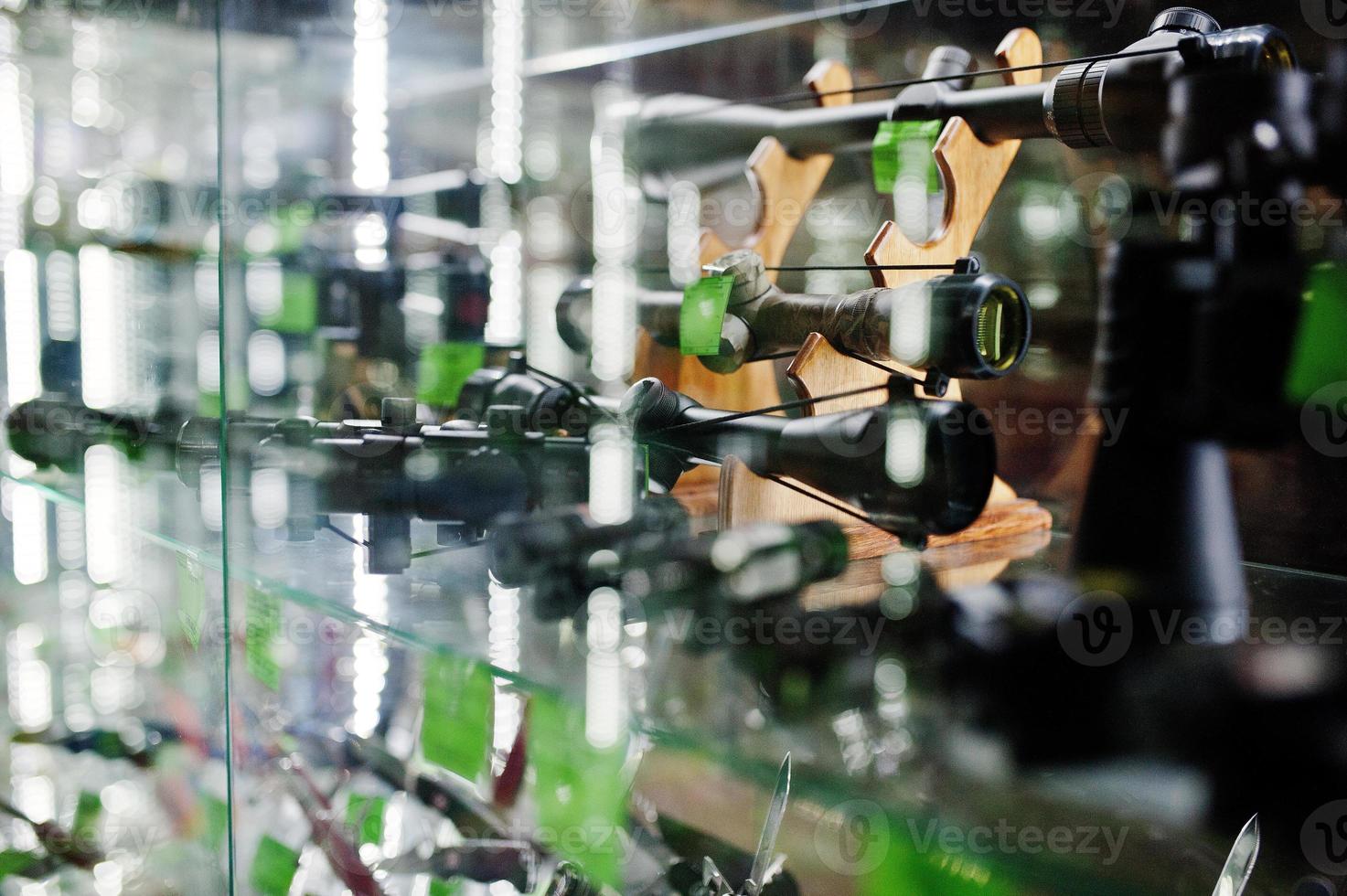 Different optical sights on shelves store weapons on shop center. photo