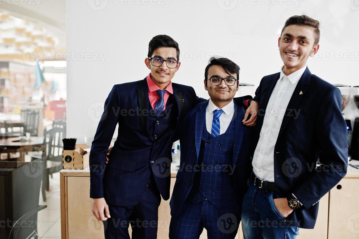 Group of three indian businessman in suits standing on cafe. photo