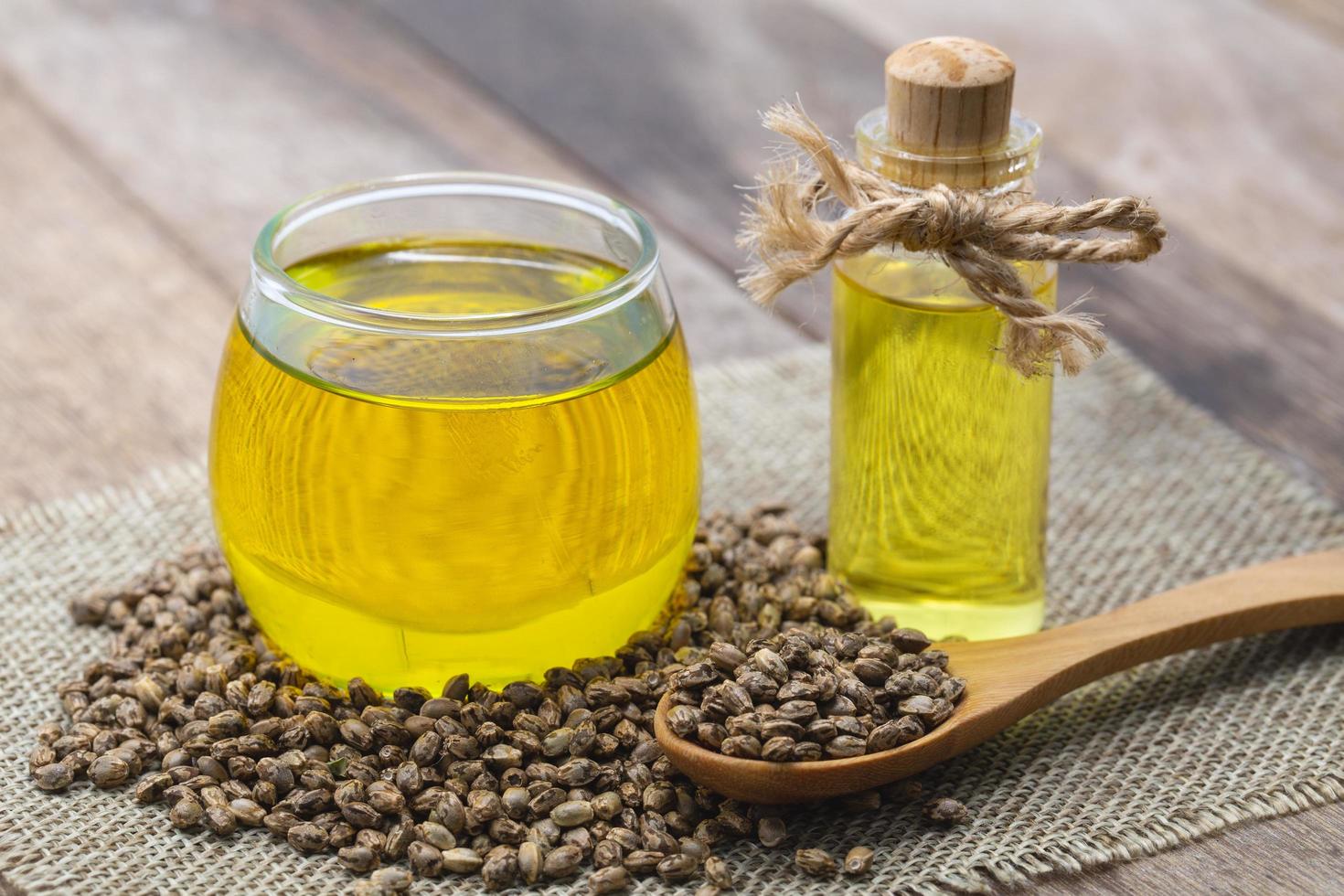 Hemp oil in a glass jar and Hemp seeds on brown wooden table. CBD  hemp oil. photo