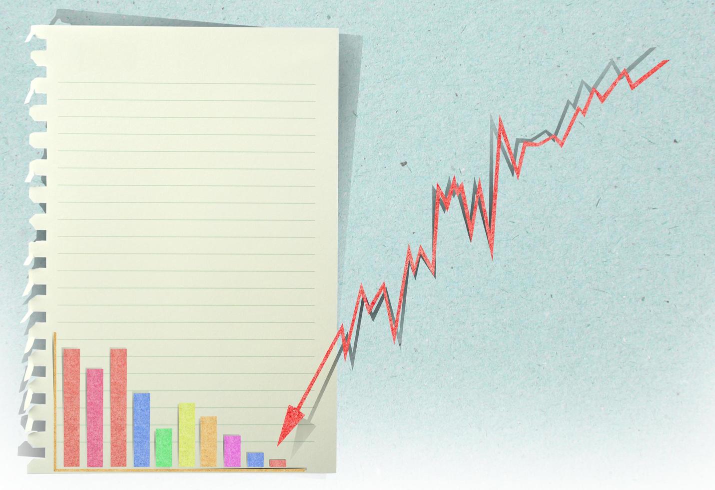 arrow graph going down with staple recycled paper craft stick photo