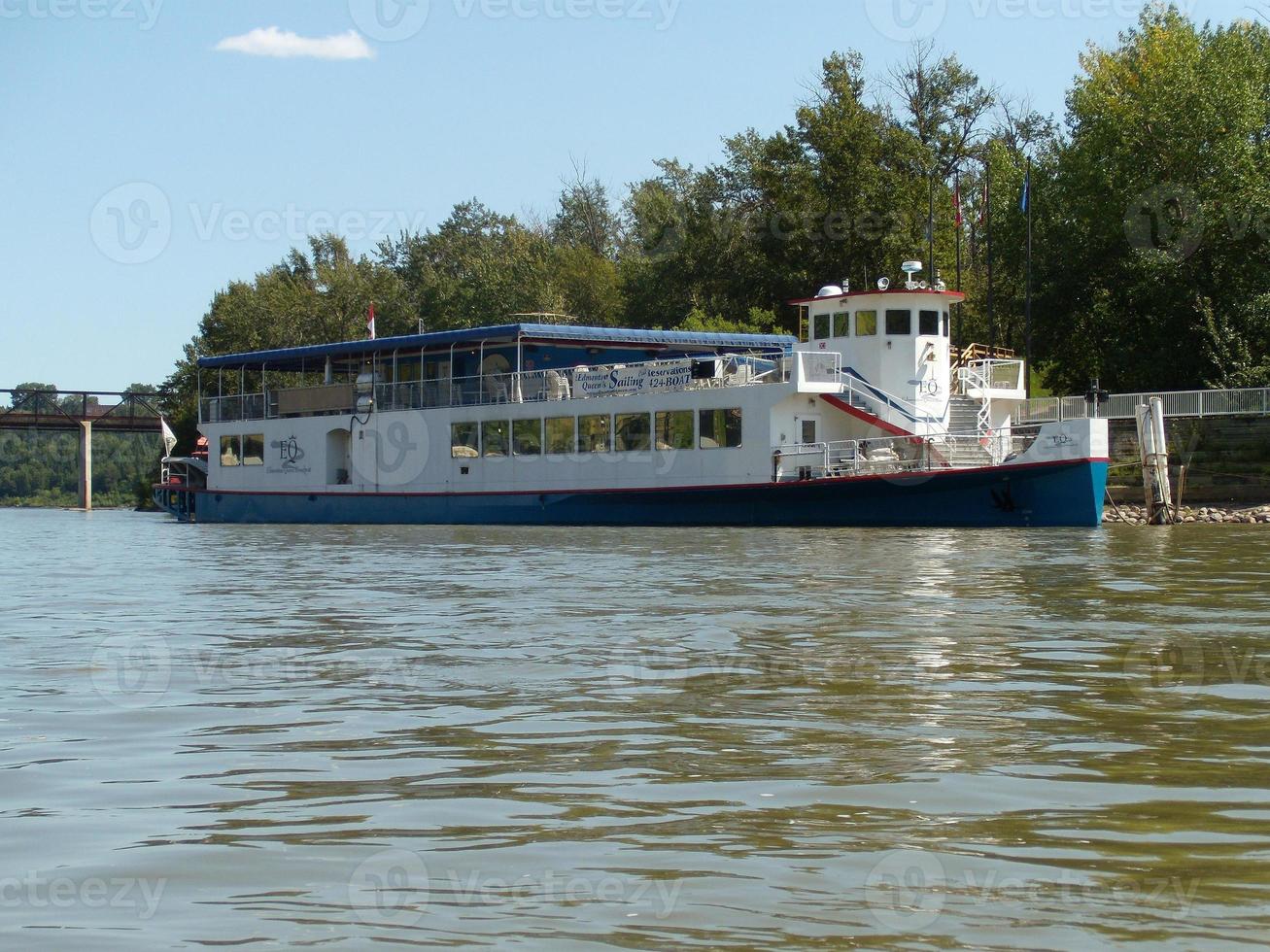 A riverboat docked by the side of the river. photo