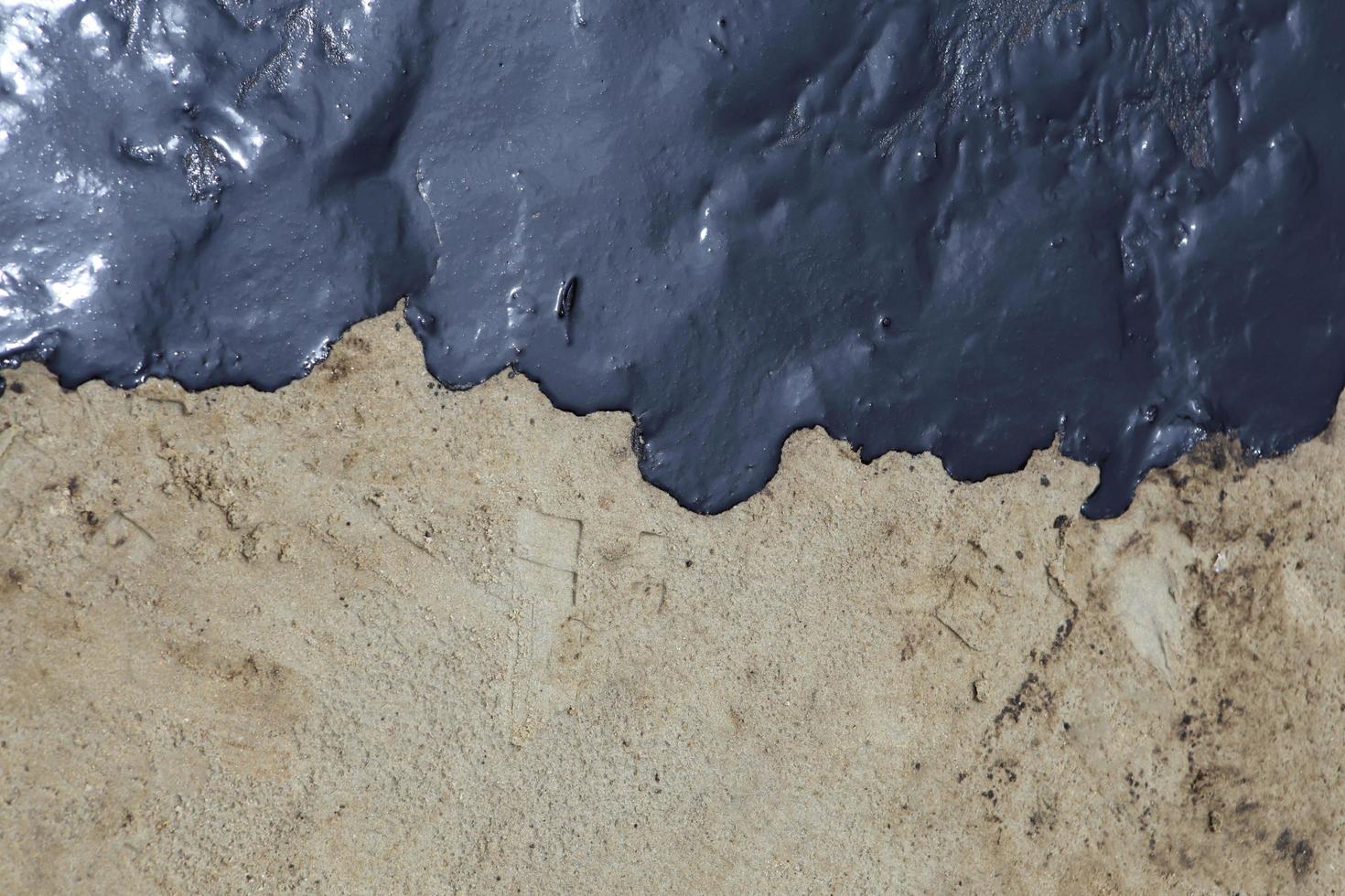 crude oil spill on the stone at the beach photo