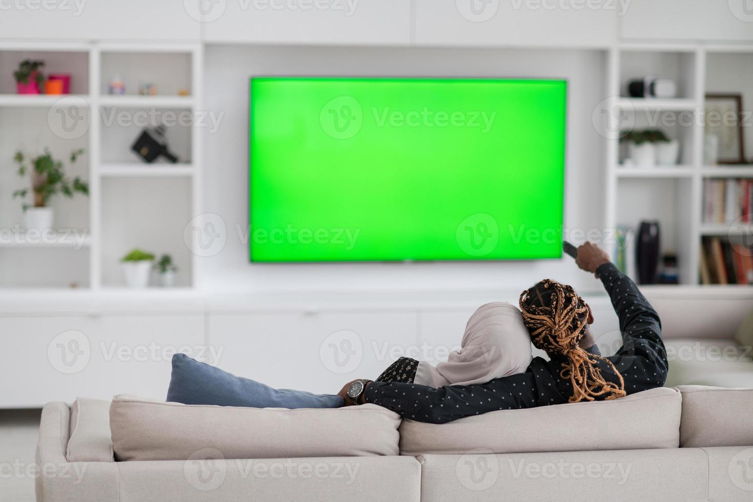 African Couple Sitting On Sofa Watching TV Together photo