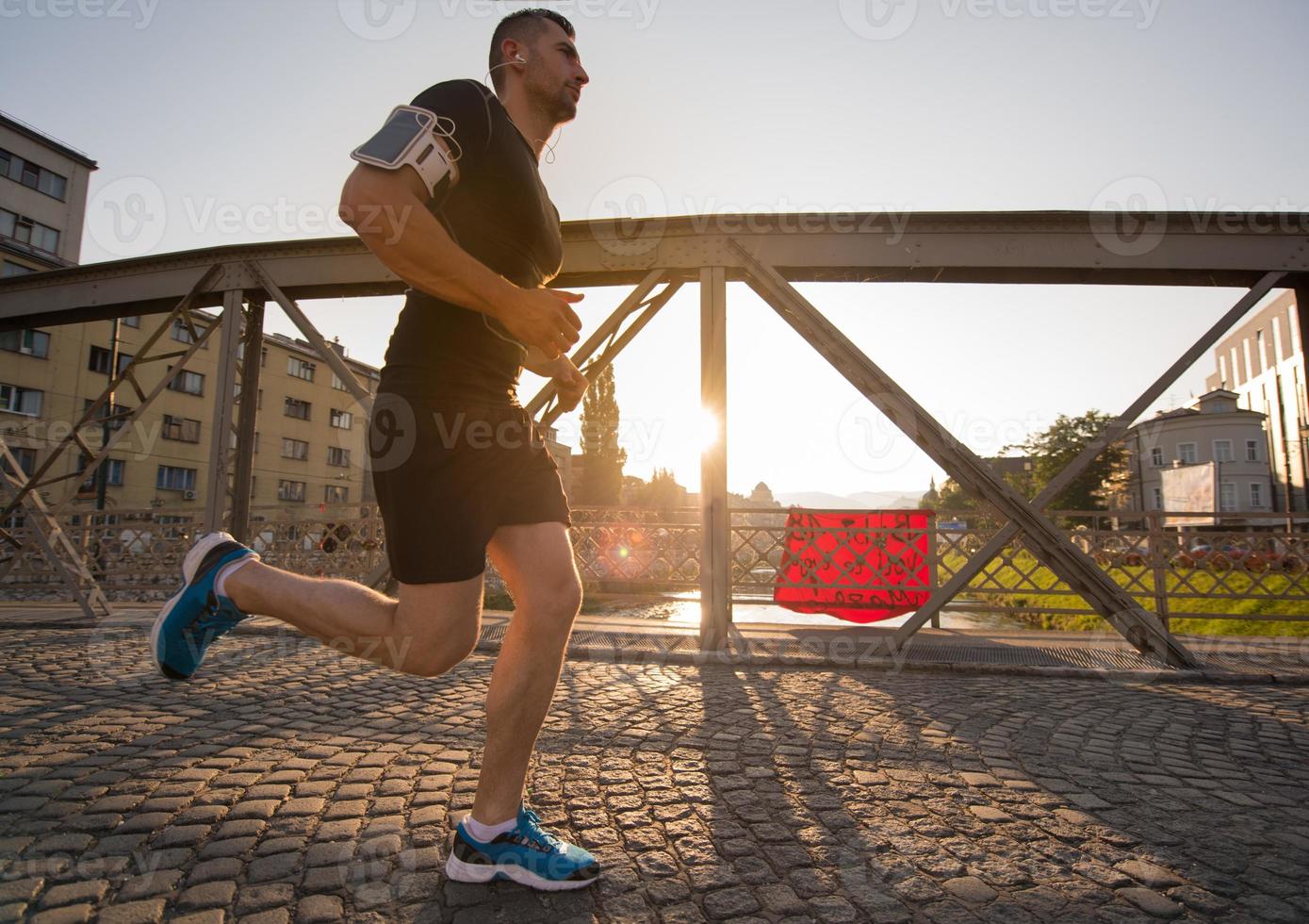 man jogging across the bridge at sunny morning photo