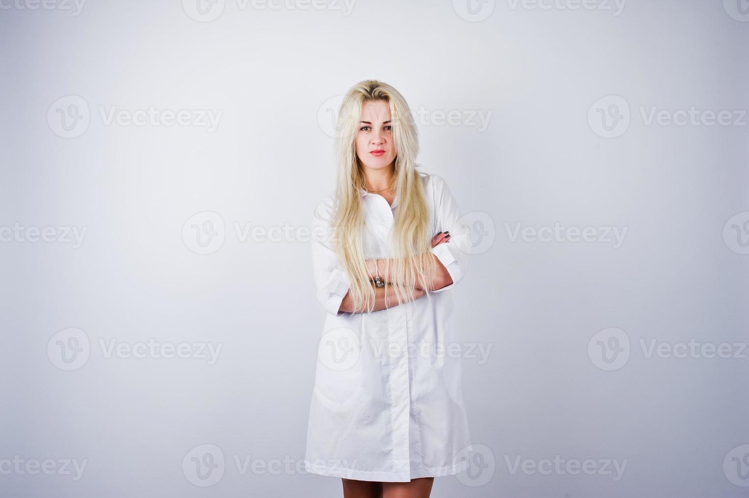 Attractive blonde female doctor or nurse  in lab coat isolated on white background. photo