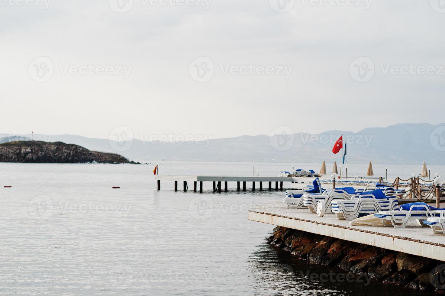 muelle con tumbonas. paisaje escénico con islas de montaña y laguna azul en el mar Egeo. paisaje exótico. punto de referencia popular, famoso destino de bodrum, turquía. foto