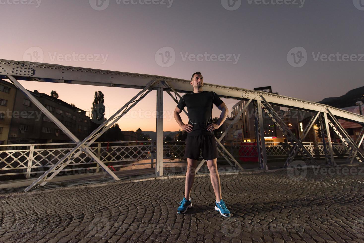 man jogging across the bridge in the city photo