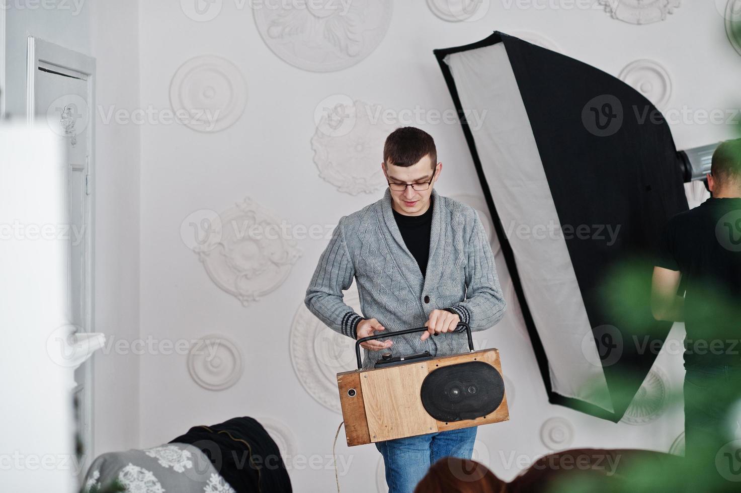 Man holding handmande tape recorder with bluetooth speaker on studio. photo