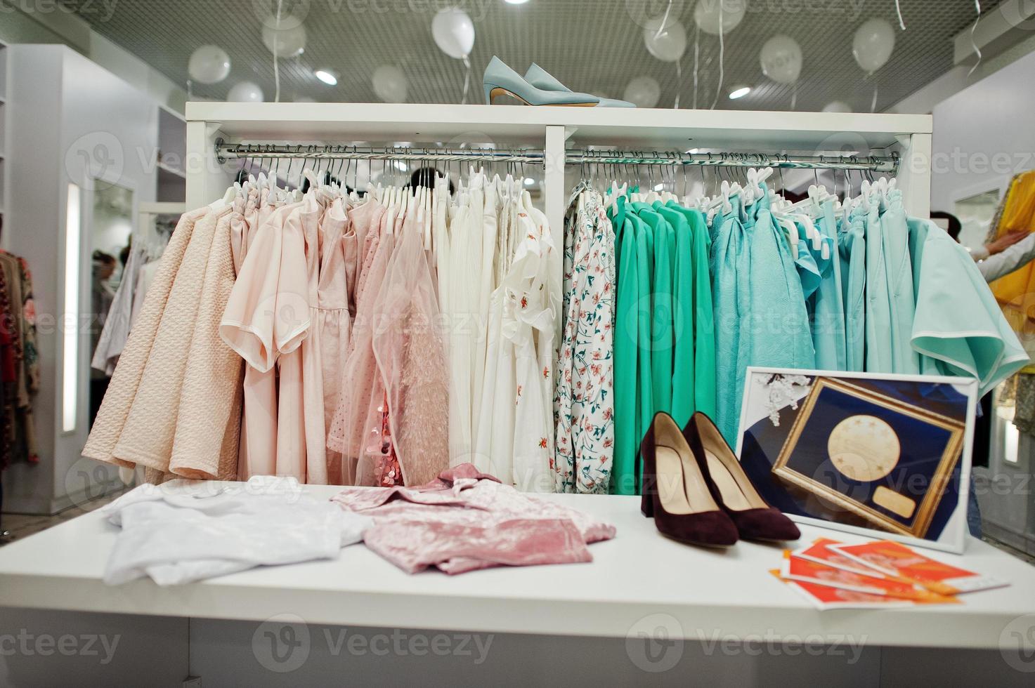 conjunto de ropa colorida femenina en los estantes con zapatos en la tienda de ropa nueva boutique moderna. de vestidos primavera verano. Foto stock en Vecteezy