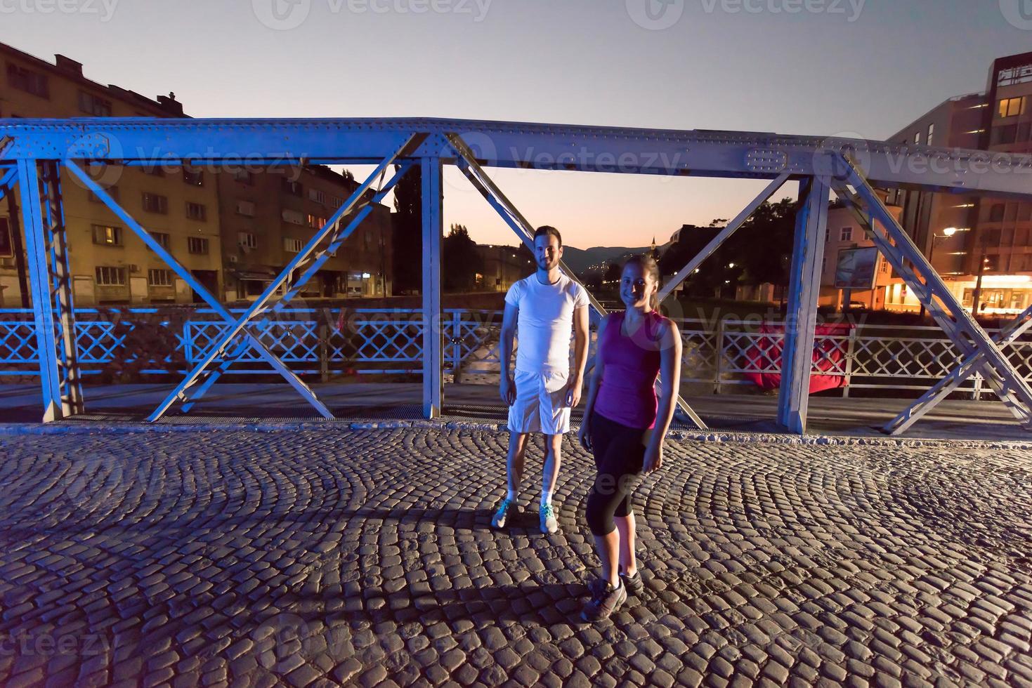 pareja corriendo por el puente en la ciudad foto