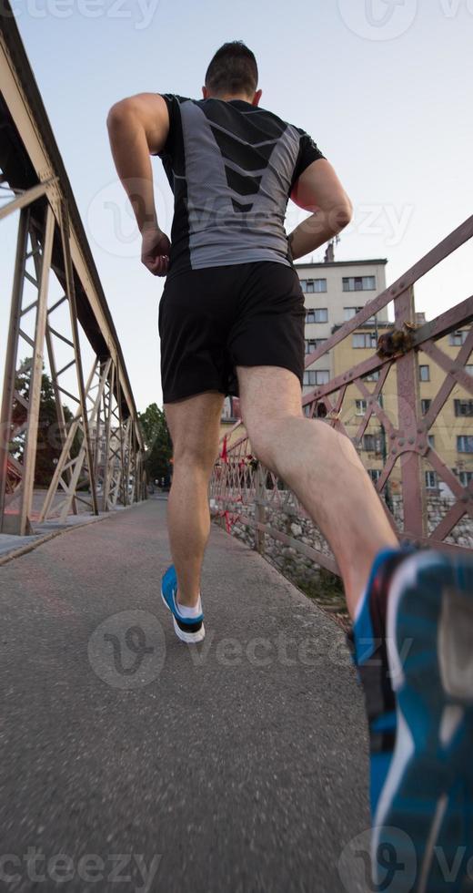 man jogging across the bridge at sunny morning photo