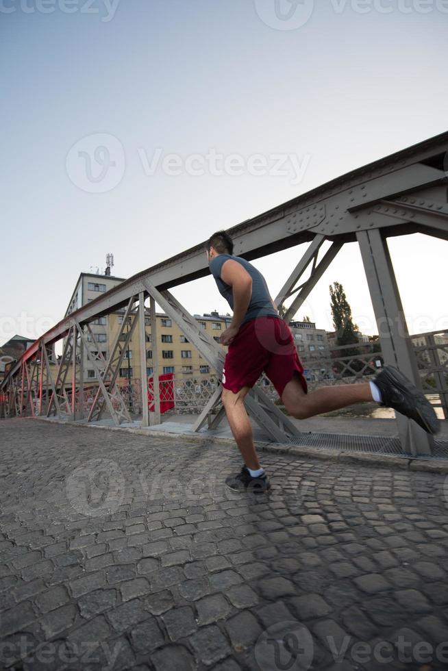 man jogging across the bridge at sunny morning photo