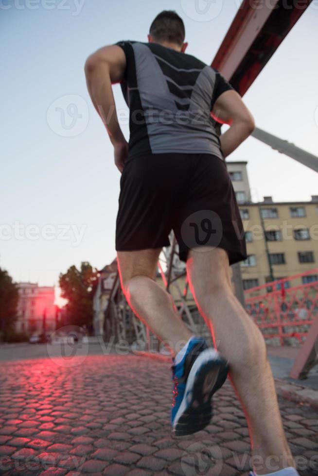 man jogging across the bridge at sunny morning photo