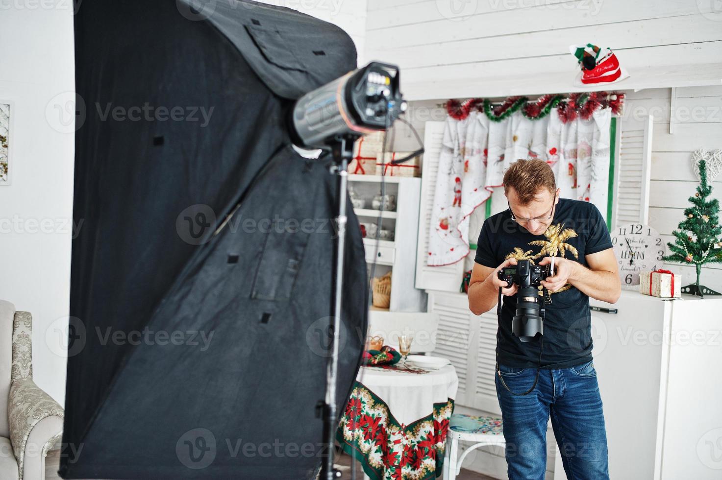 Man photographer looking at camera for result what him shoot on studio. Professional photographer on work. photo