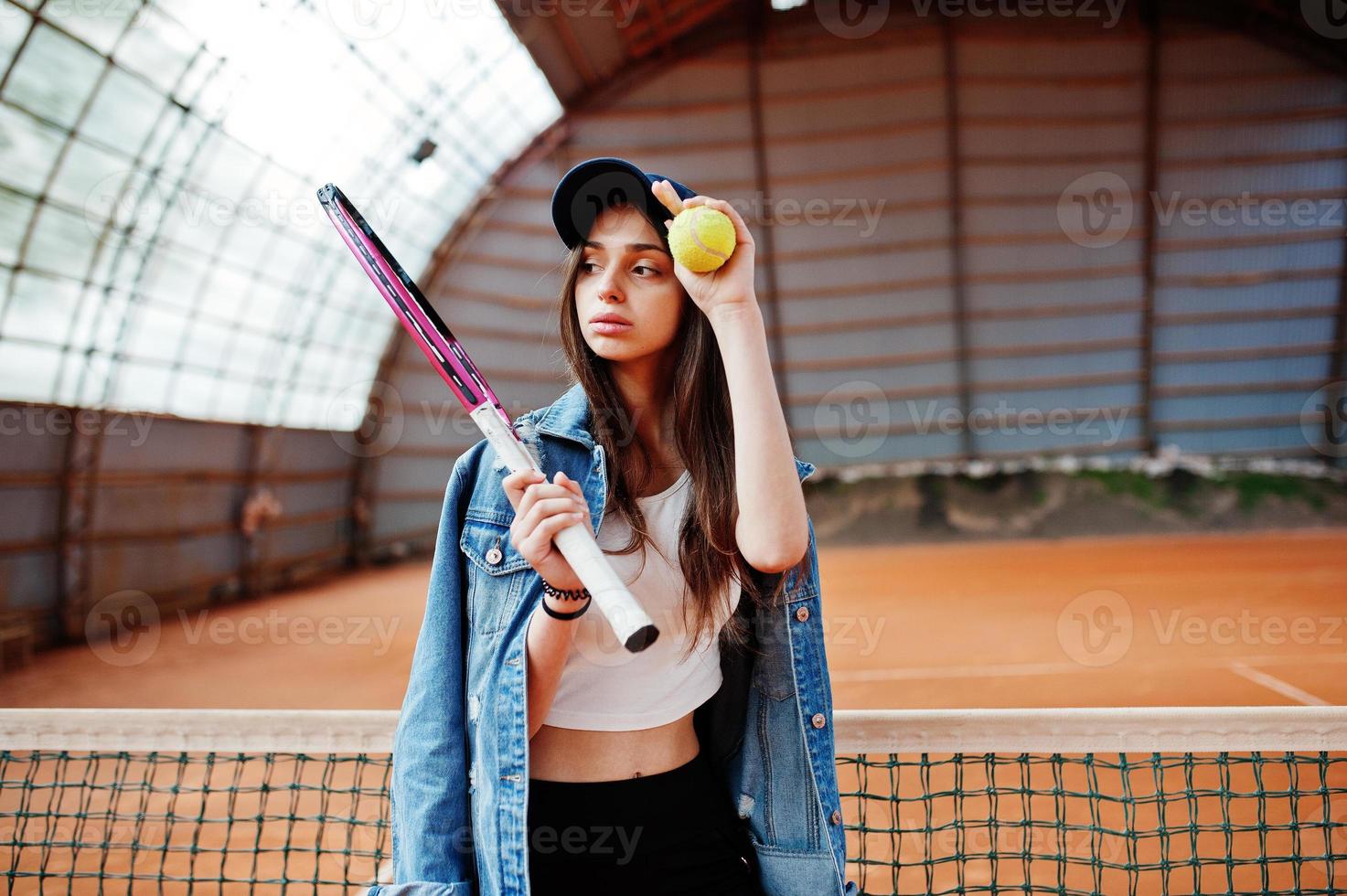 Young sporty girl player with tennis racket on tennis court. photo