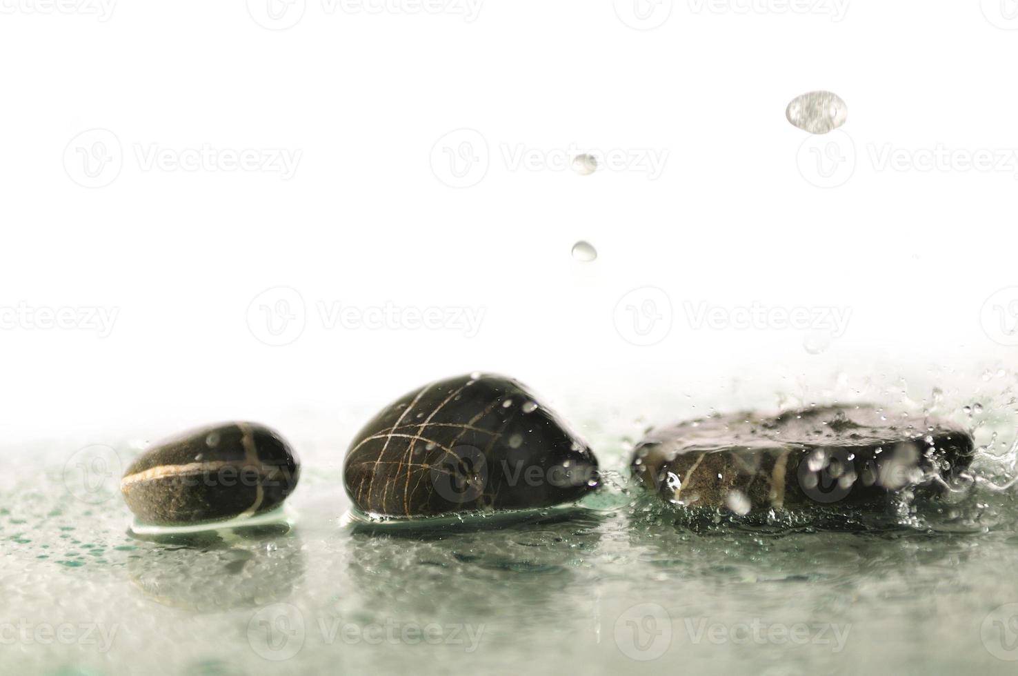 piedras zen húmedas aisladas con gotas de agua salpicadas foto