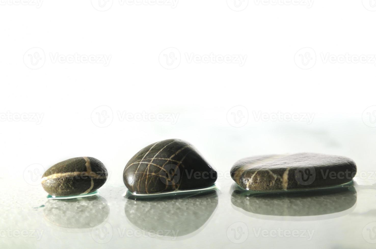 isolated wet zen stones with splashing  water drops photo