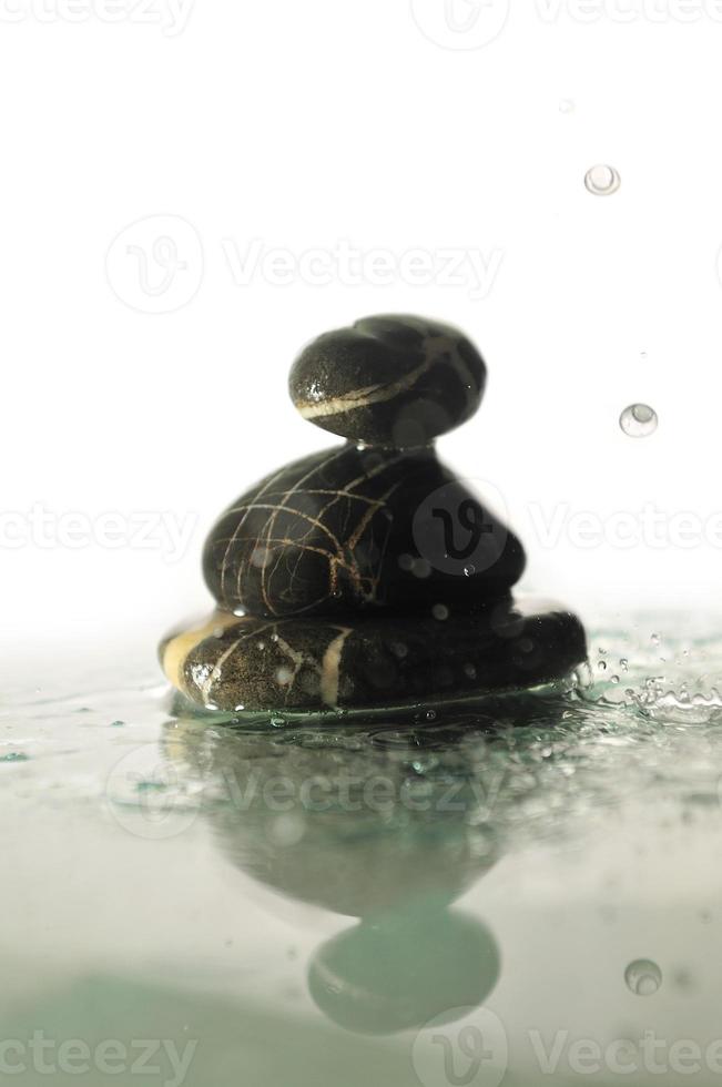 isolated wet zen stones with splashing  water drops photo