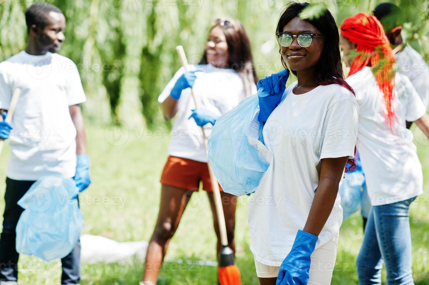 grupo de voluntarios africanos felices con área de limpieza de bolsas de basura en el parque. Concepto de voluntariado, caridad, personas y ecología de África. foto