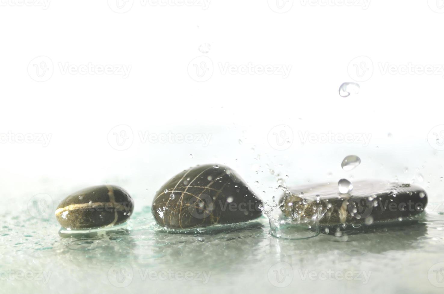 isolated wet zen stones with splashing  water drops photo