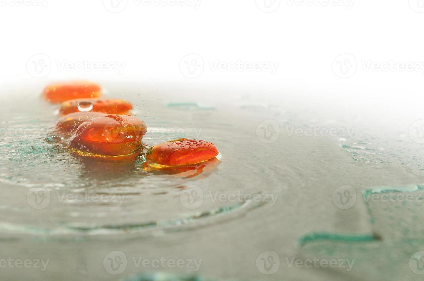 piedras zen húmedas aisladas con gotas de agua salpicadas foto