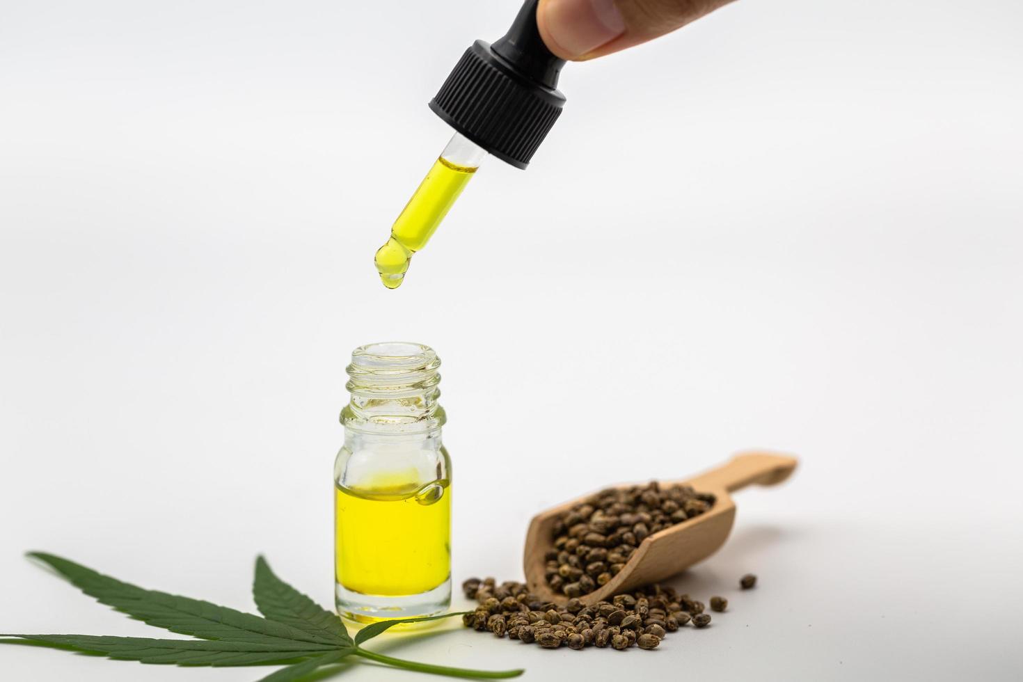 Hemp seeds and  droplet dosing a biological and ecological hemp plant herbal pharmaceutical cbd oil from a jar On a white background.  medical marijuana concept, CBD cannabis OIL. photo